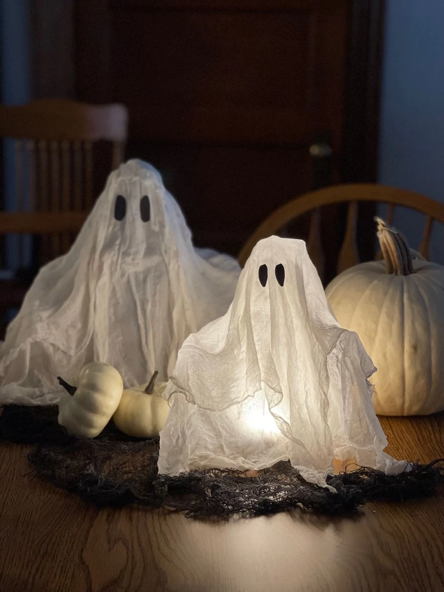 Cute ghost decor idea 1: Drape Glowing Fairy Lights Under Mini Sheet Ghosts