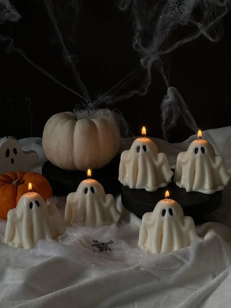 Cute ghost decor idea 20: Burn Ghost-Shaped Candles on a Black Table