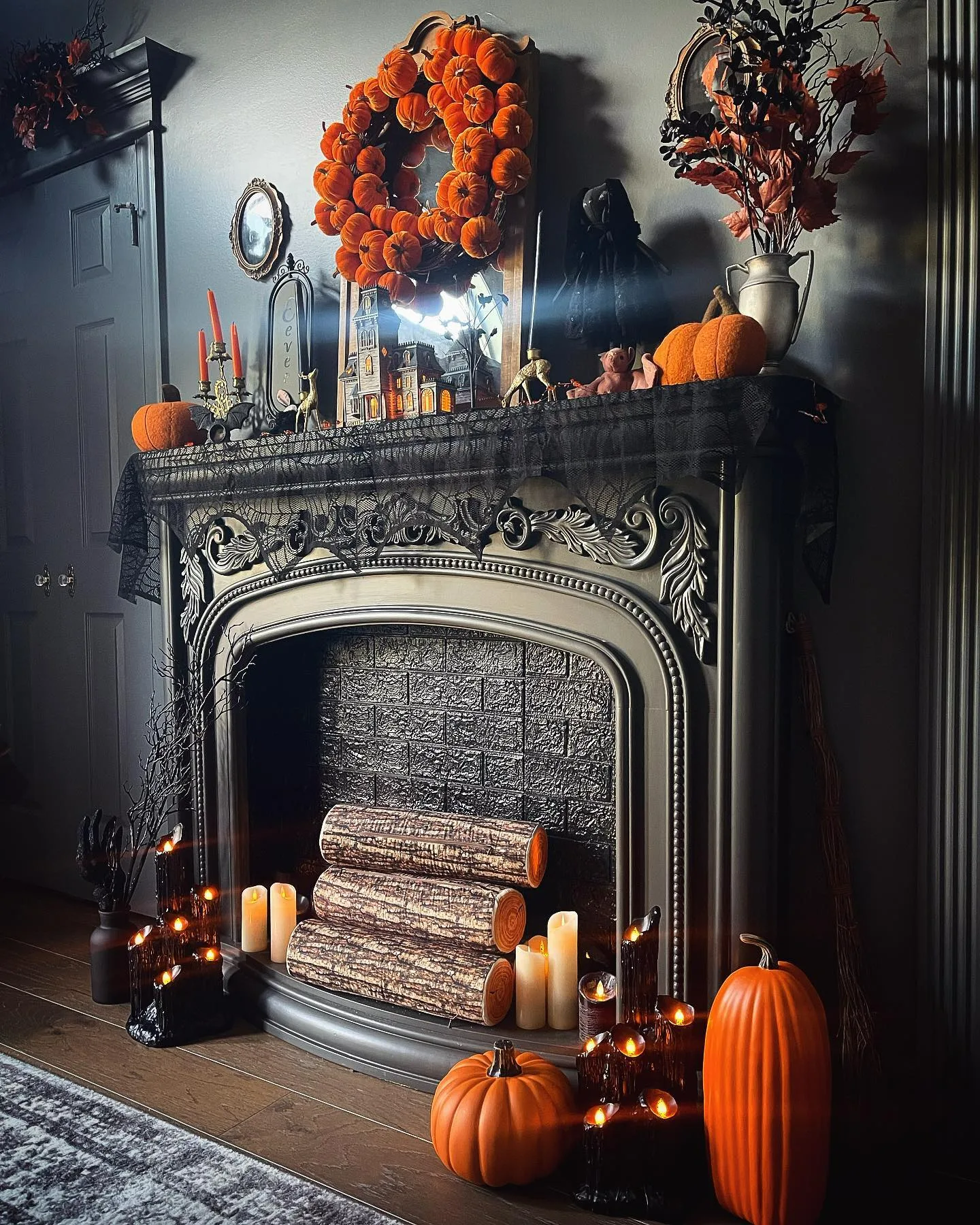 Gothic Halloween decor idea 21: Layer a Gothic Mantel With a Pumpkin Wreath and Black Lace
