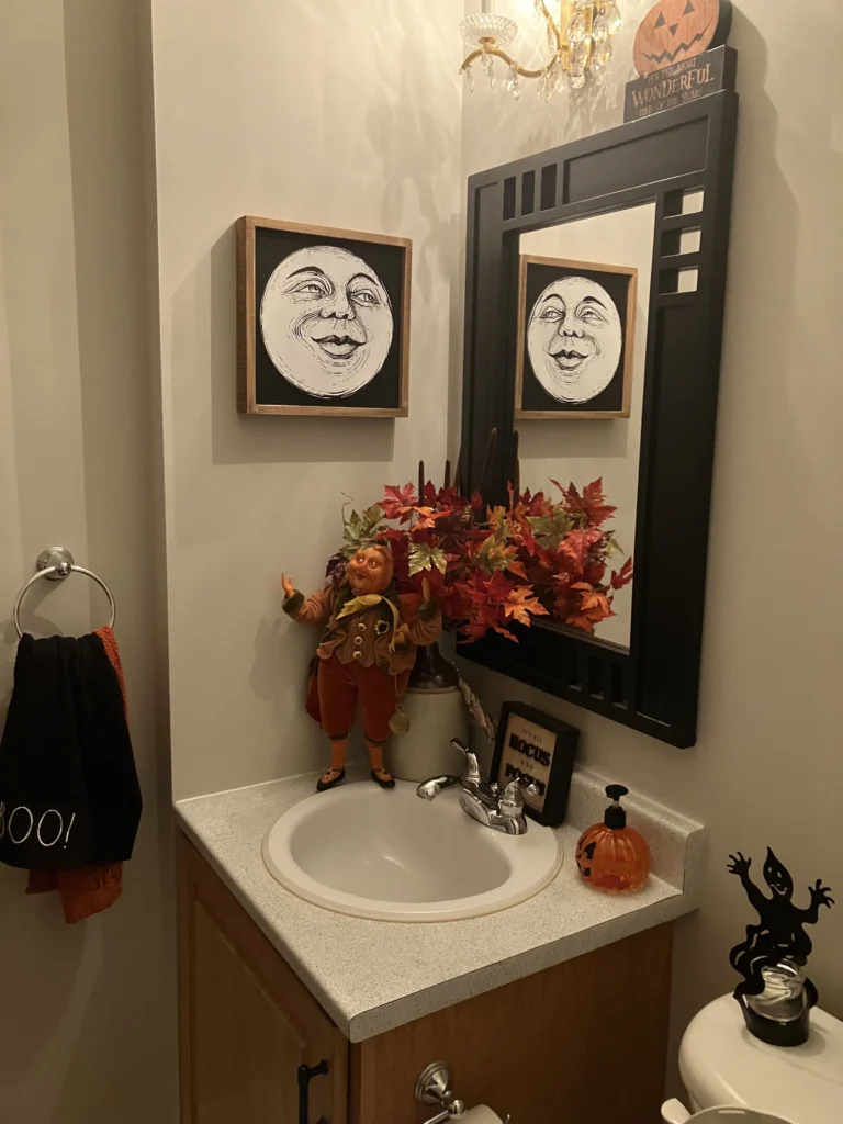 Halloween bathroom decorating idea 7: Hang Moon Face Art Beside the Powder Room Mirror