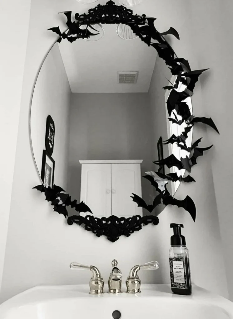 Halloween bathroom decorating idea 9: Ring an Oval Mirror With a Wreath of Black Bats