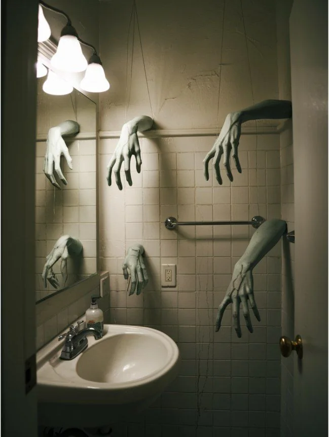 Halloween bathroom decorating idea 20: Let Zombie Hands Reach Out of the Tile Walls