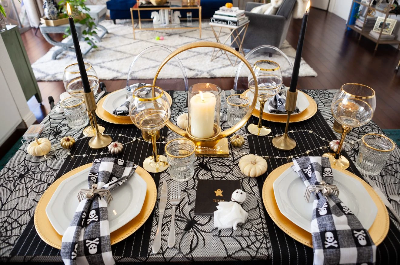 Halloween tablescape idea 9: Go Glam With Black, Gold, and Spiderweb Chargers