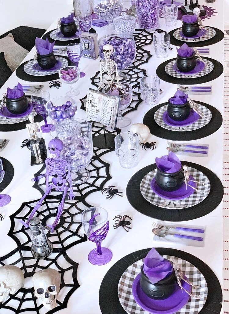 Halloween tablescape idea 12: Top Every Plate With a Mini Witch Hat