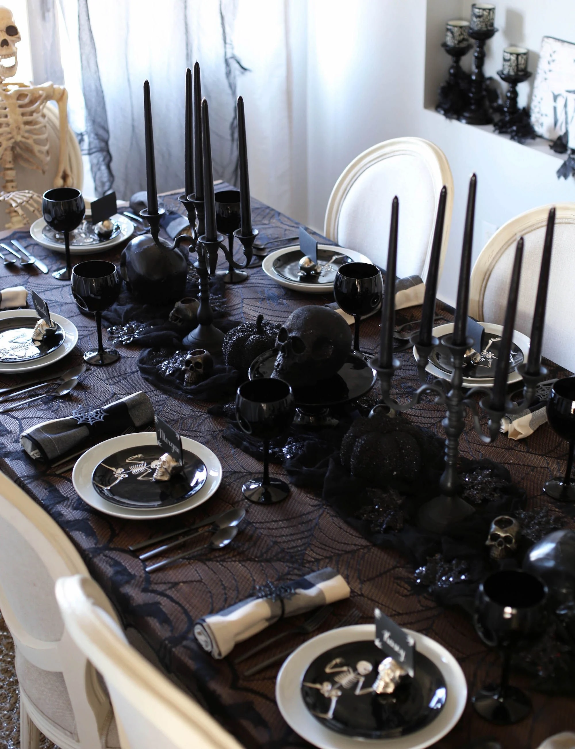 Halloween tablescape idea 21: Line Up Tall Black Candlesticks for Instant Drama