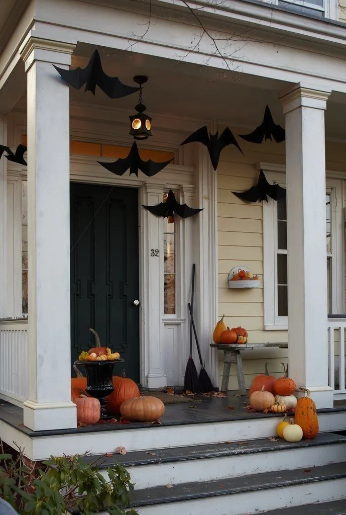 Vintage Halloween decor idea 22: Build a Vintage Porch With Brooms, Bats, and Pumpkins